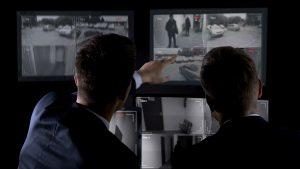 Deux agents de dos analysant une vidéo de sécurité