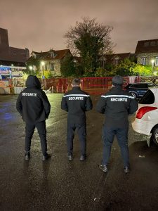 Trois agents de sécurité posant dos a l'objectif avec leur uniforme