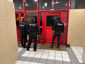Controle d'acces fait par trois agents de sécurité en noir