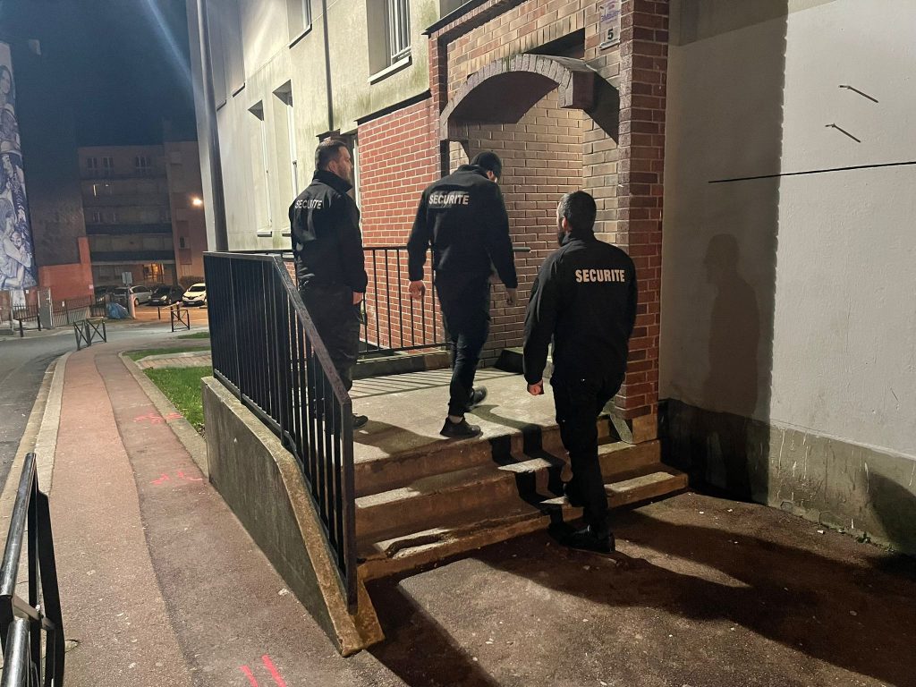 Trois agents de sécurités en noir faisant leur ronde de nuit